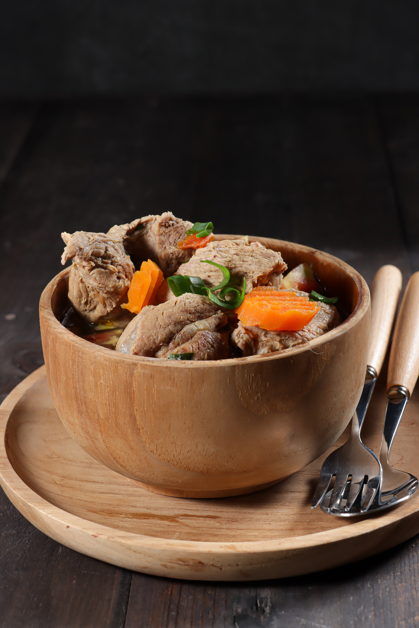 Sup Kambing or Mutton Soup or stewed lamb soup served with sliced ​​tomatoes, and carrots.